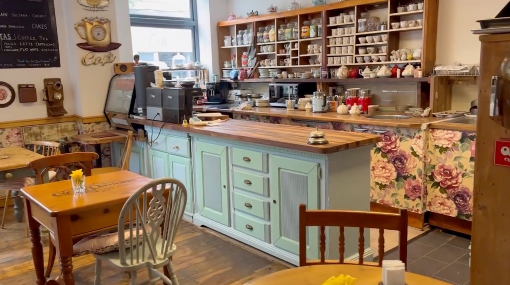Inside The Vintage Vault coffee shop in Sheerness: serving counter, vintage teacups, seating and blackboard menu